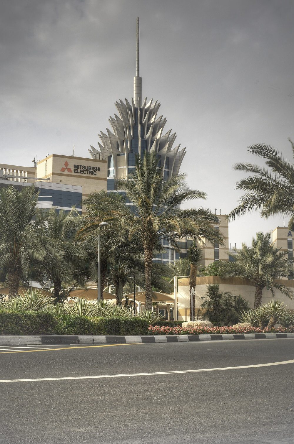 The Dubai Silicon Oasis headquarters tower behind palm trees.